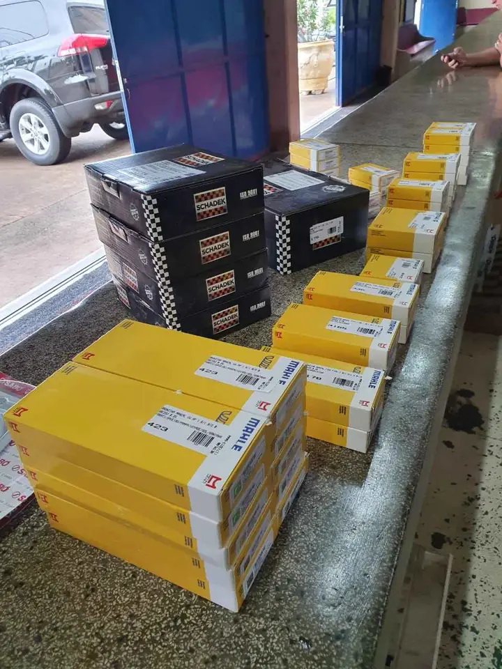 Balcão de atendimento da loja com caixas MAHLE e SCHADEK enfileiradas, com a entrada ao fundo