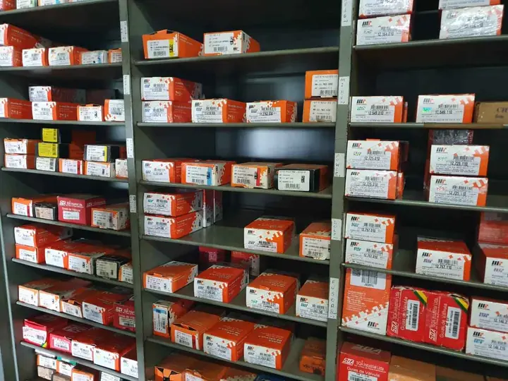 Estante com caixas de guias de válvula separadas por aplicação, identificadas com etiquetas escritas à mão